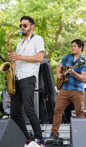 man playing saxophone on stage at home rule music festival